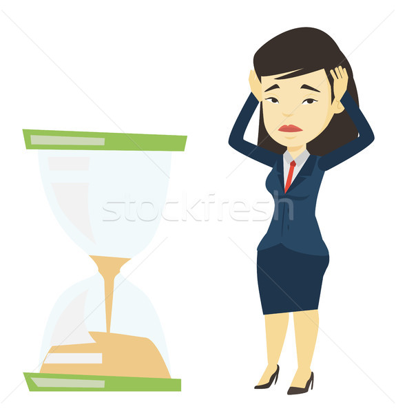 Desperate business woman looking at hourglass. Stock photo © RAStudio