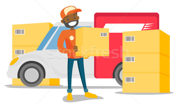 Young african delivery man carrying cardboard box. Stock photo © RAStudio