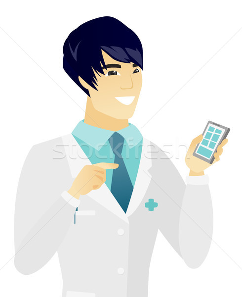 Young asian doctor holding a mobile phone. Stock photo © RAStudio