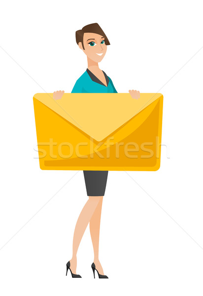 Stock photo: Smiling business woman holding a big envelope.