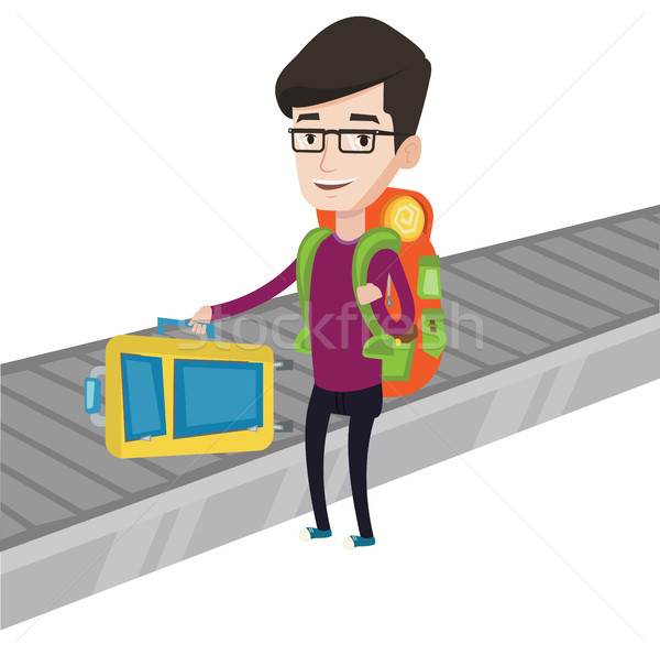 Man picking up suitcase on luggage conveyor belt. Stock photo © RAStudio