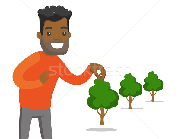 Young african-american gardener plants a tree. Stock photo © RAStudio