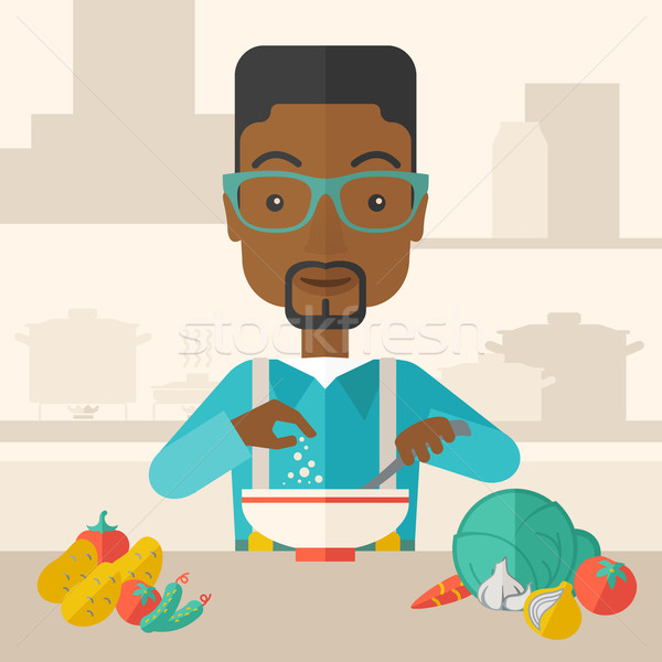 Young black guy is eating salad for lunch in the restaurant. Stock photo © RAStudio