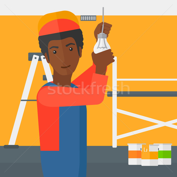Electrician twisting light bulb. Stock photo © RAStudio