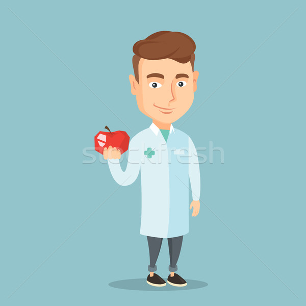 Nutritionist oferind proaspăt red apple tineri caucazian Imagine de stoc © RAStudio