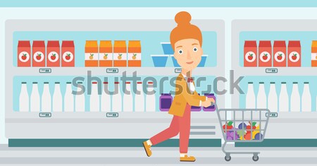 Klant jonge vrouw voortvarend supermarkt winkelwagen goederen Stockfoto © RAStudio