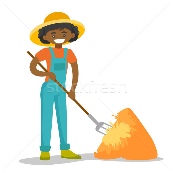 A black happy woman with a pitchfork and a haystack. Stock photo © RAStudio