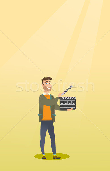 Smiling man holding an open clapperboard. Stock photo © RAStudio