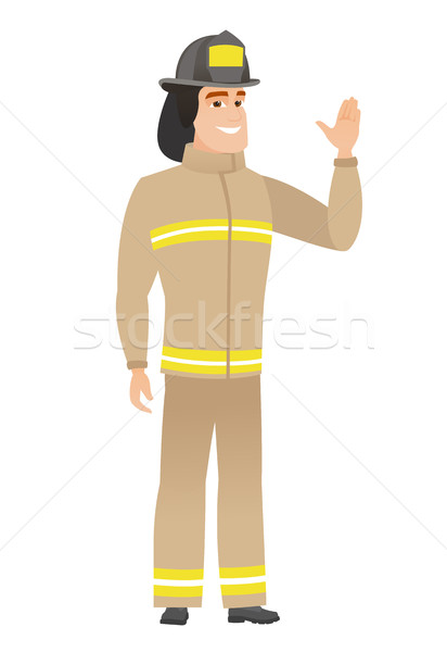 Young caucasian firefighter waving his hand. Stock photo © RAStudio