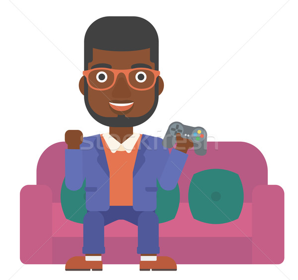 Człowiek gry gra wideo posiedzenia sofa gamepad Zdjęcia stock © RAStudio