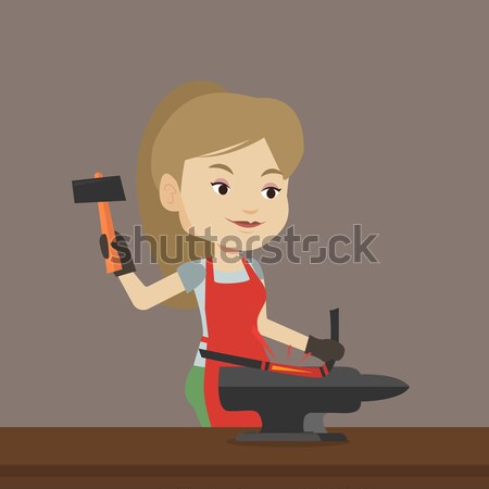 Stock photo: Blacksmith working metal with hammer on the anvil.