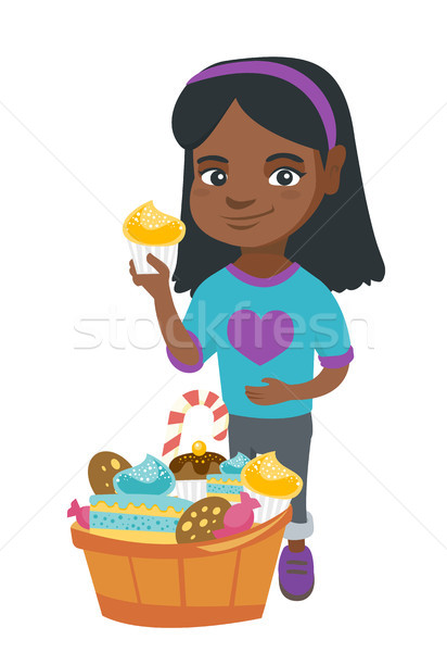 Girl holding a cupcake and stroking her belly. Stock photo © RAStudio