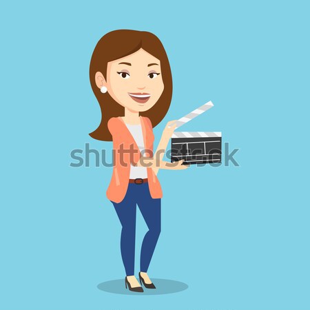 Smiling woman holding an open clapperboard. Stock photo © RAStudio