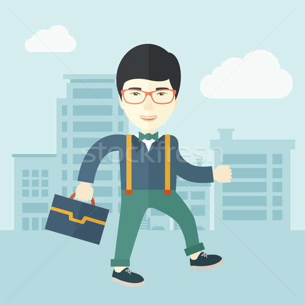 Young man walking through the city street with his briefcase. Stock photo © RAStudio