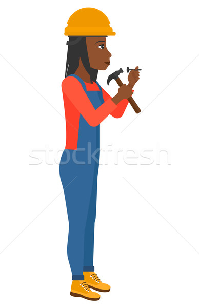 Woman hammering nail. Stock photo © RAStudio