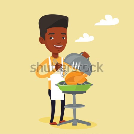 Stock photo: Man cooking chicken on barbecue grill.