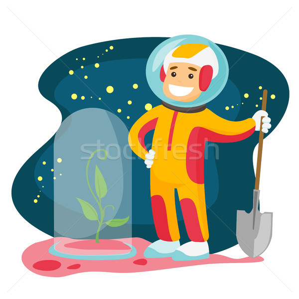 Stock photo: Caucasian astronaut planting tree on a new planet.