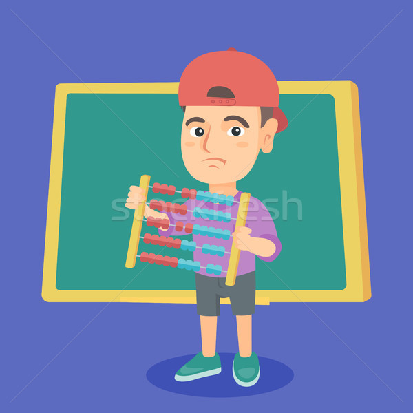 Boy with abacus on the background of blackboard. Stock photo © RAStudio