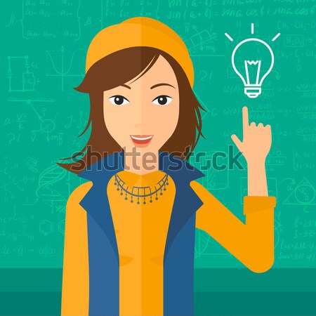 Woman pointing at light bulb. Stock photo © RAStudio