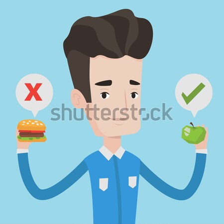 Man choosing between hamburger and cupcake. Stock photo © RAStudio