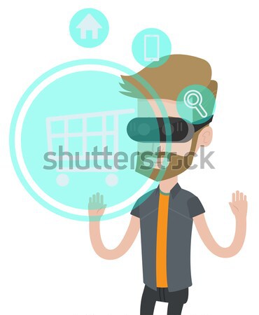 Stock photo: Man in virtual reality headset shopping online.