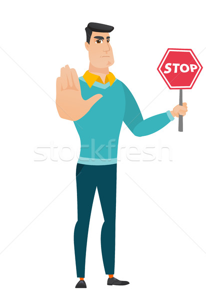 Caucasian businessman holding stop road sign. Stock photo © RAStudio