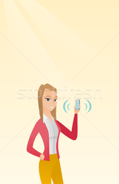 Young caucasian woman holding ringing mobile phone Stock photo © RAStudio