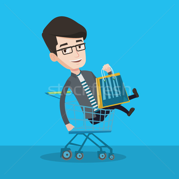 Happy man riding by shopping trolley. Stock photo © RAStudio