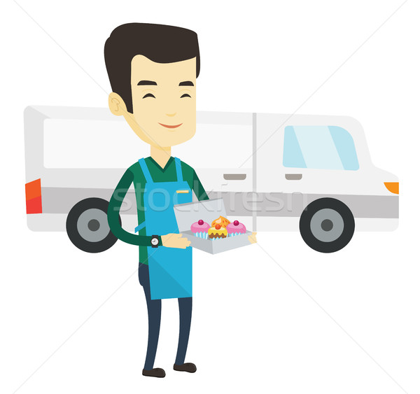 Delivery man holding a box of cakes. Stock photo © RAStudio
