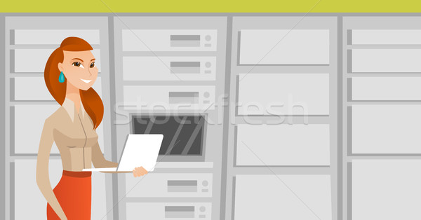 Engineer working on laptop in network server room. Stock photo © RAStudio