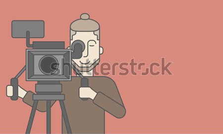 Cameraman with beard looking through movie camera Stock photo © RAStudio