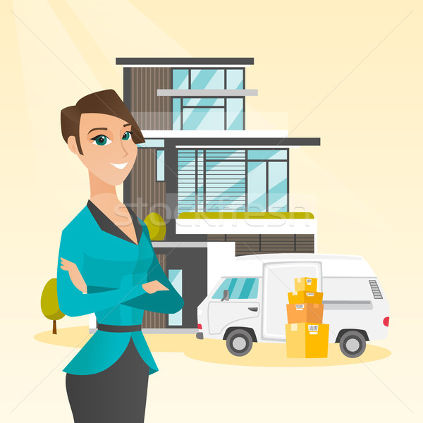 Stock photo: Young caucasian woman moving to a house.