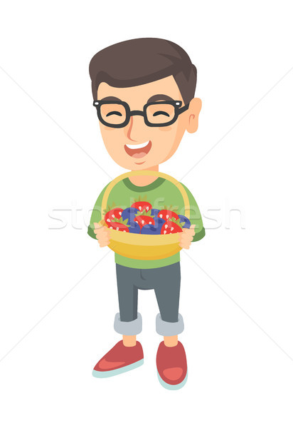 Boy with the basket of strawberry and blueberry. Stock photo © RAStudio