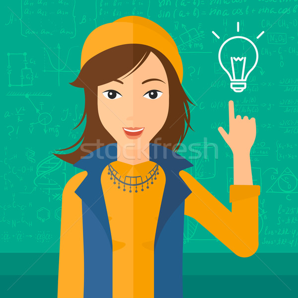 Woman pointing at light bulb. Stock photo © RAStudio