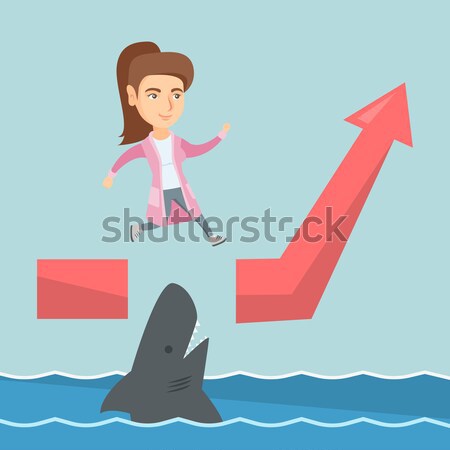 Stock photo: Business man jumping over ocean with shark.