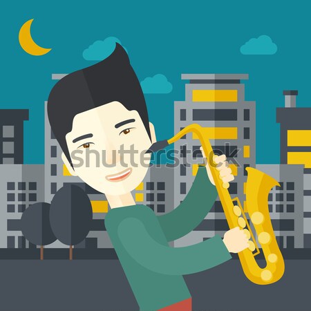 Saxophonist playing in the streets at night Stock photo © RAStudio