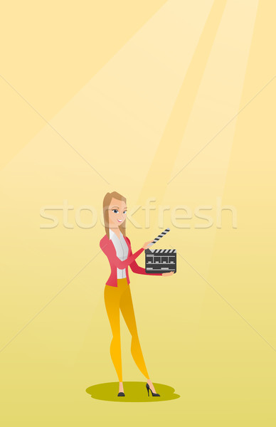 Smiling woman holding an open clapperboard. Stock photo © RAStudio