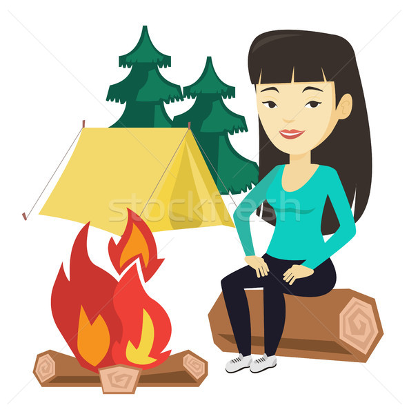 Woman sitting on log near campfire in the camping. Stock photo © RAStudio