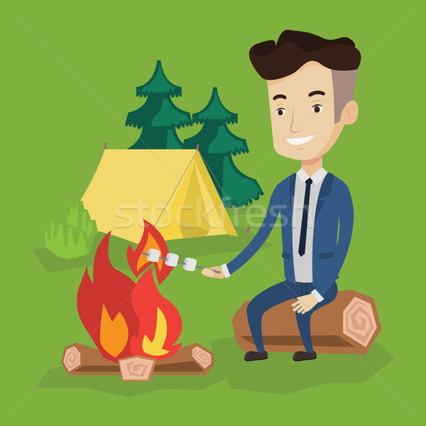 Businessman roasting marshmallow over campfire. Stock photo © RAStudio