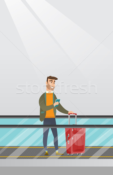 Man using smartphone on escalator at the airport. Stock photo © RAStudio