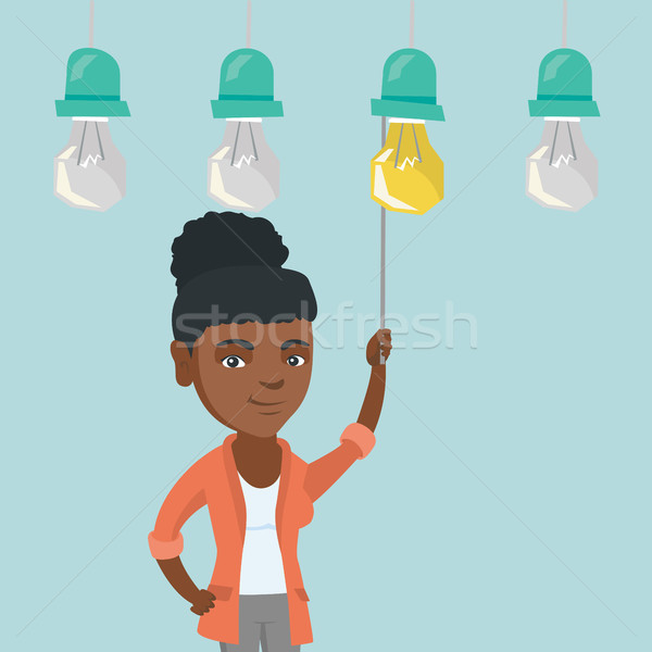 Business woman switching on hanging idea bulb. Stock photo © RAStudio