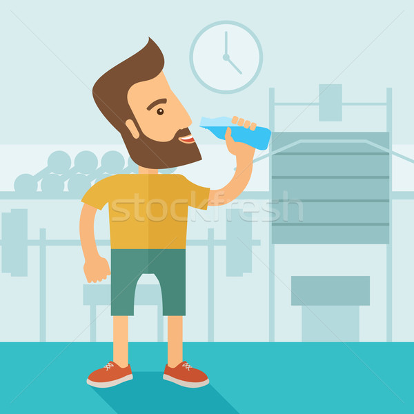Gentleman drink a bottle of water while inside the gym. Stock photo © RAStudio