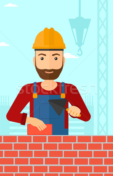 Bricklayer with spatula and brick. Stock photo © RAStudio