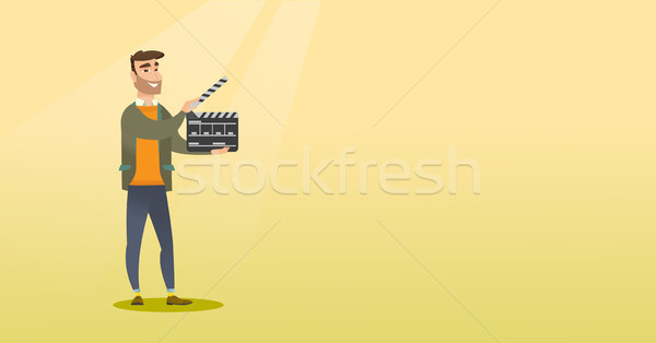 Smiling man holding an open clapperboard. Stock photo © RAStudio