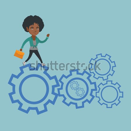 Stock photo: Business man running on cogwheels.