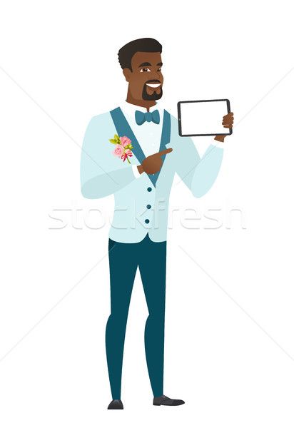 Smiling groom holding tablet computer. Stock photo © RAStudio