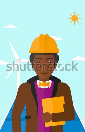 Male worker of solar power plant and wind farm. Stock photo © RAStudio