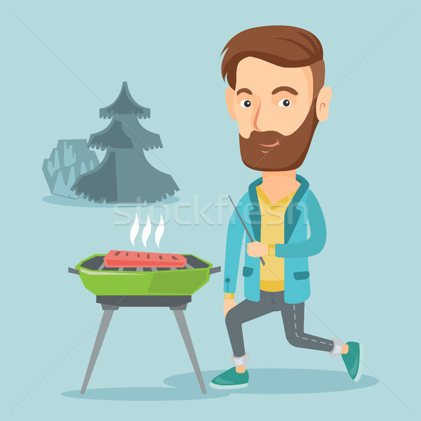 Stock photo: Man cooking steak on barbecue grill.