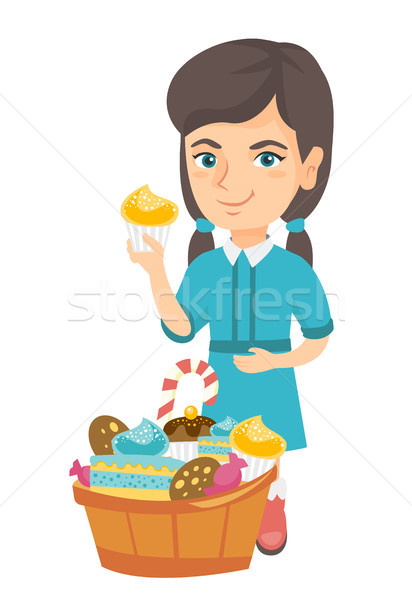 Girl holding a cupcake and stroking her belly. Stock photo © RAStudio