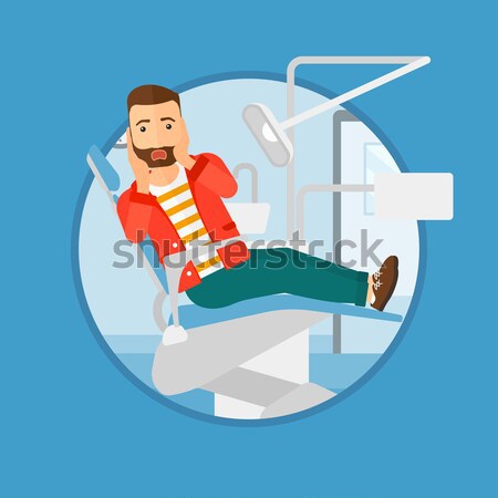 Stock photo: Scared patient sitting dental chair.
